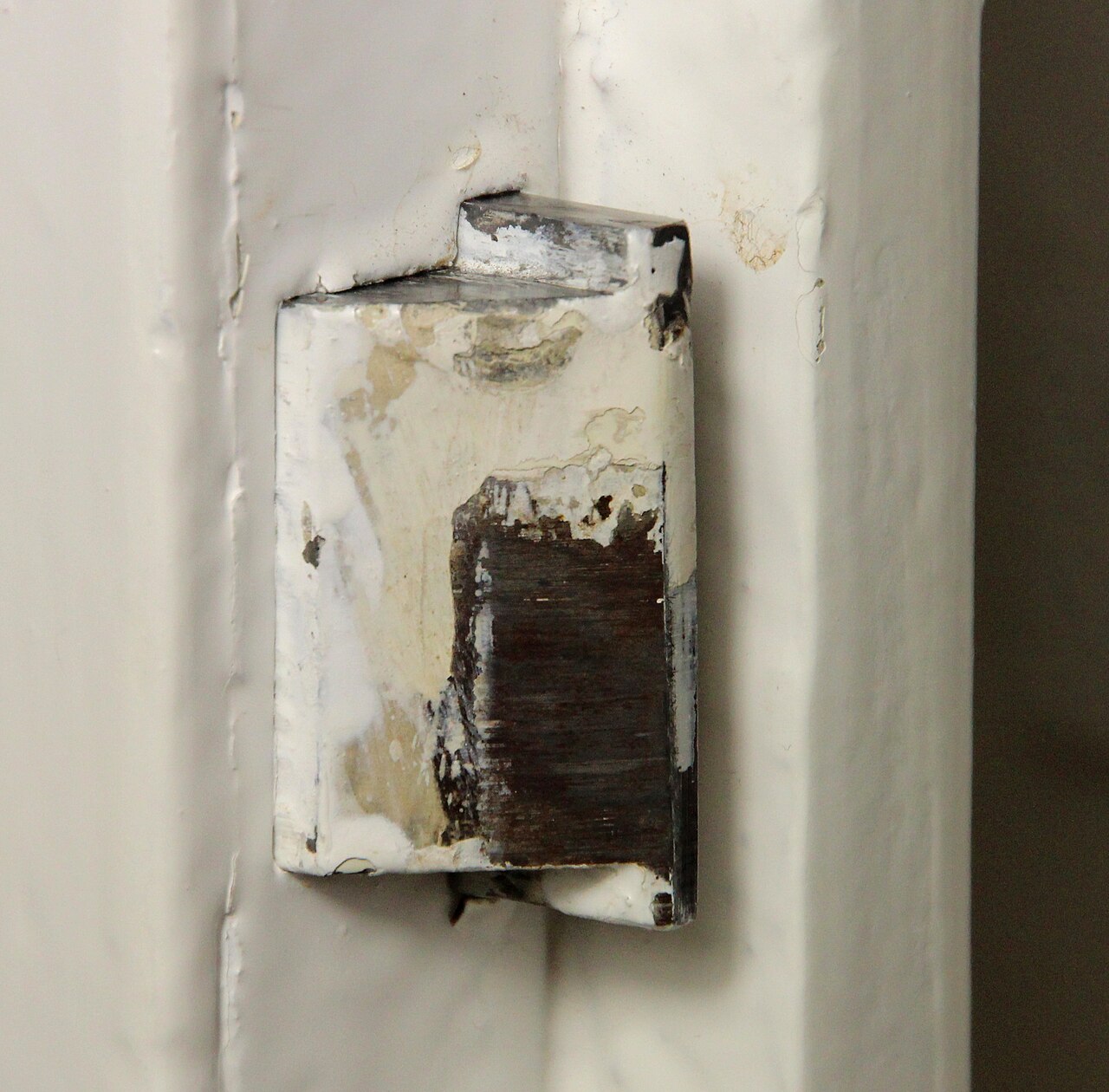 Trinco de fechadura em porta pintada de branco, close-up