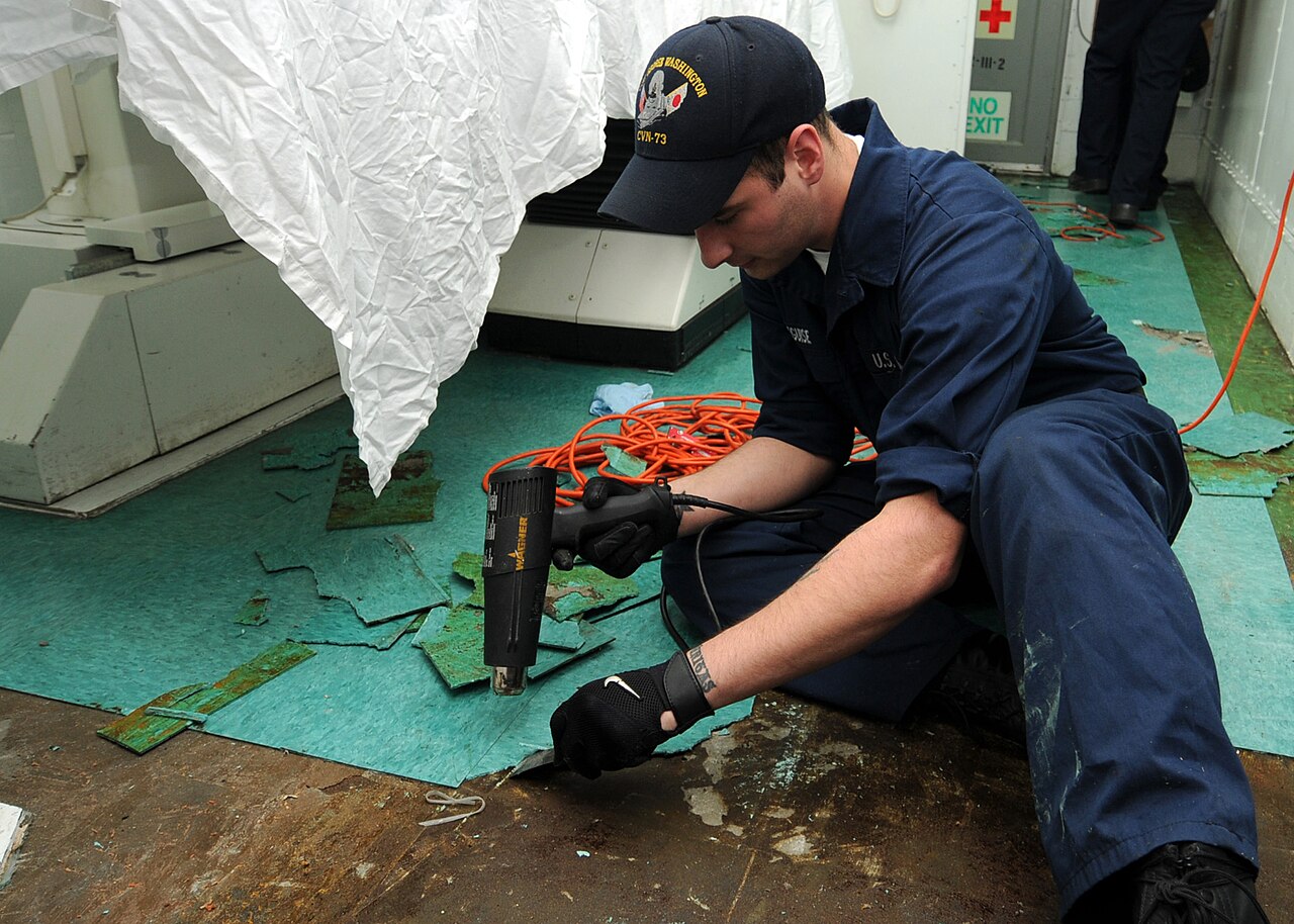 Pessoa usando soprador térmico para remover material de uma superfície