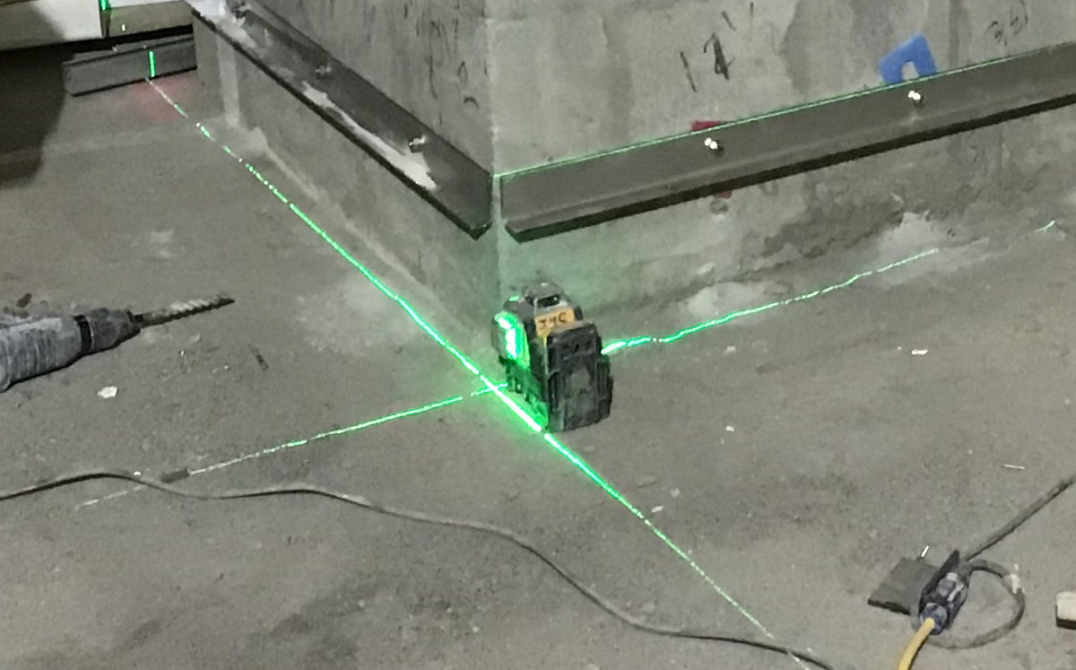 Nível laser de linha projetando feixes de 90 graus no chão durante uma instalação