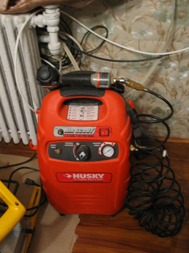 Compressor de ar pequeno tipo pancake em oficina doméstica
