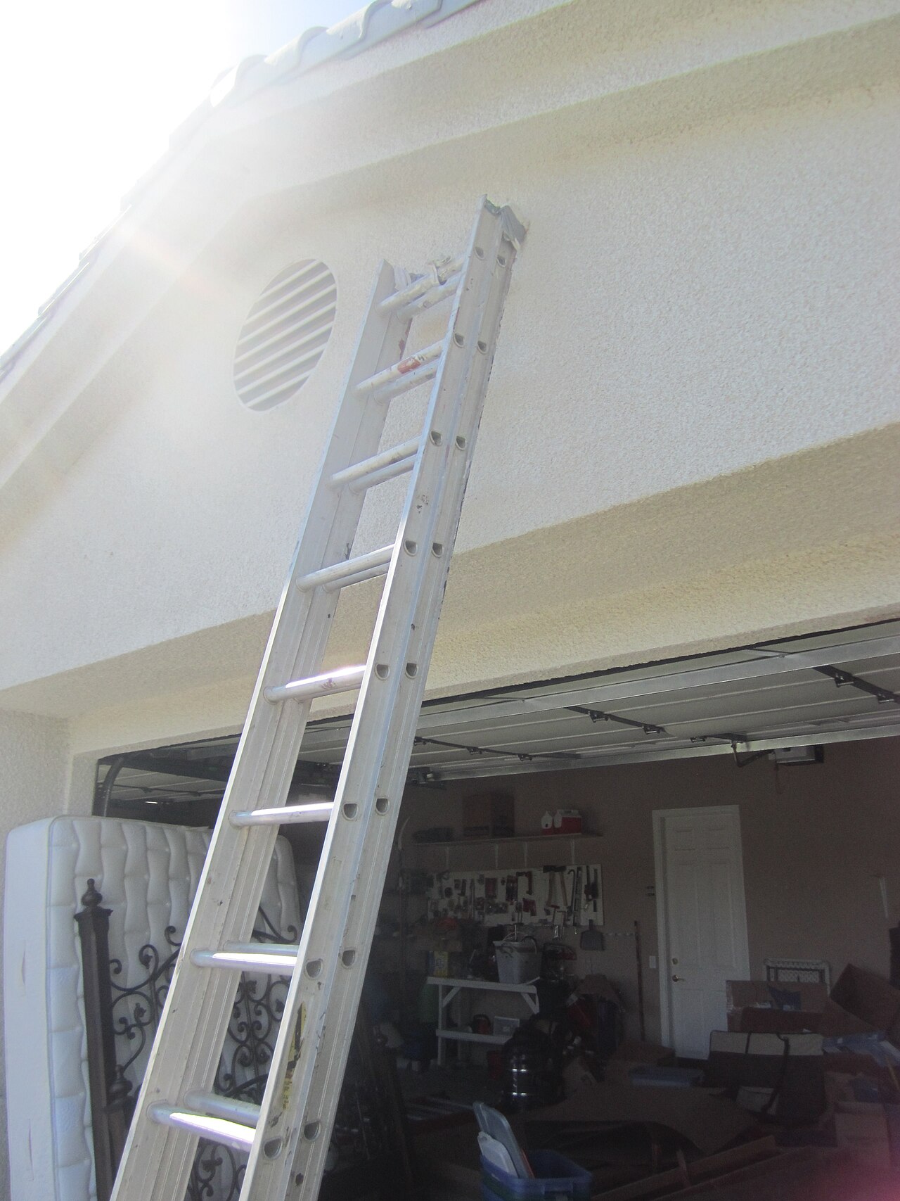 Escada extensível apoiada na parede de uma garagem
