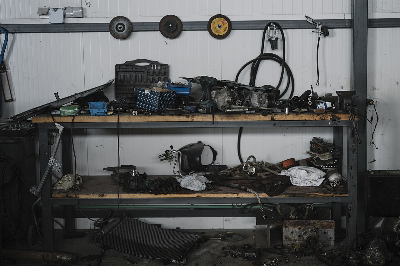 Bancada de garagem com ferramentas e peças organizadas