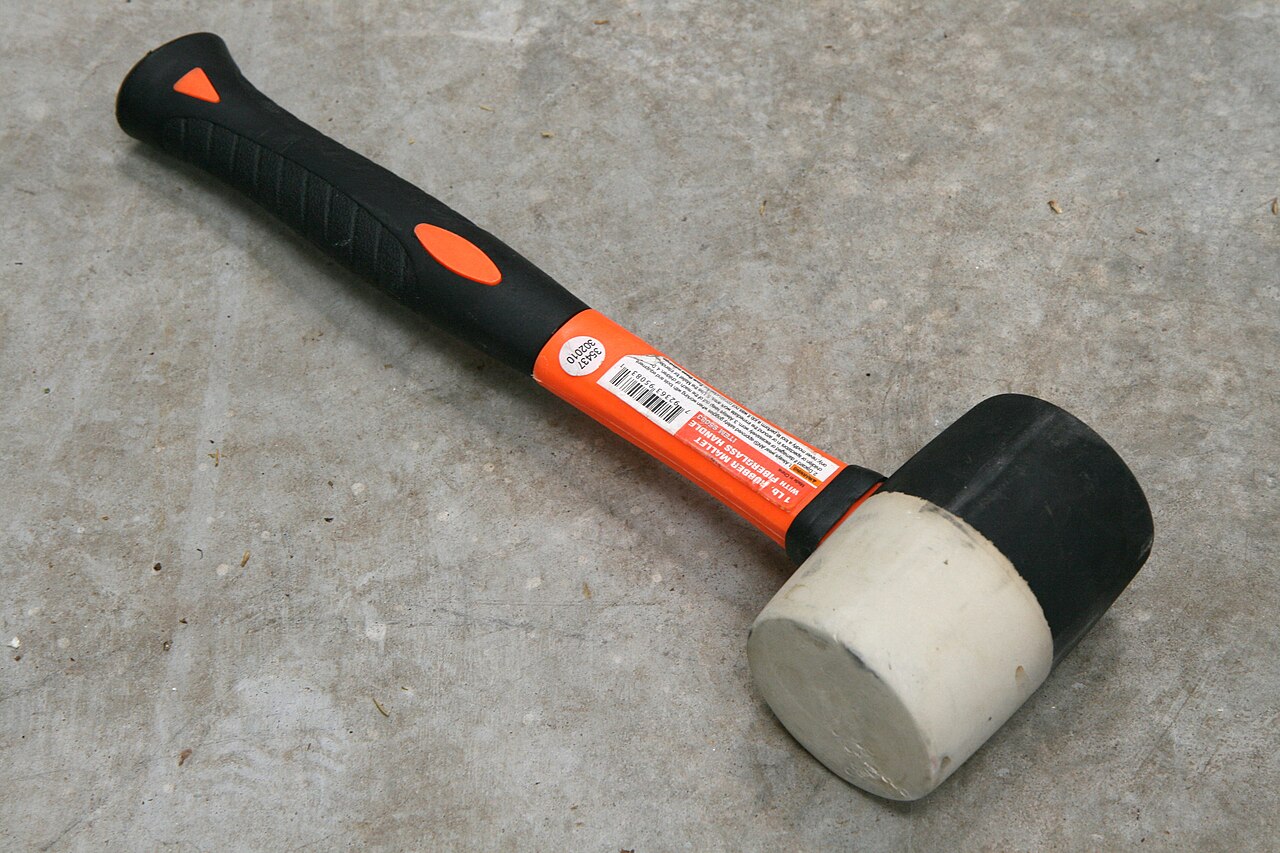 Martelo de borracha com cabo de fibra de vidro apoiado no chão