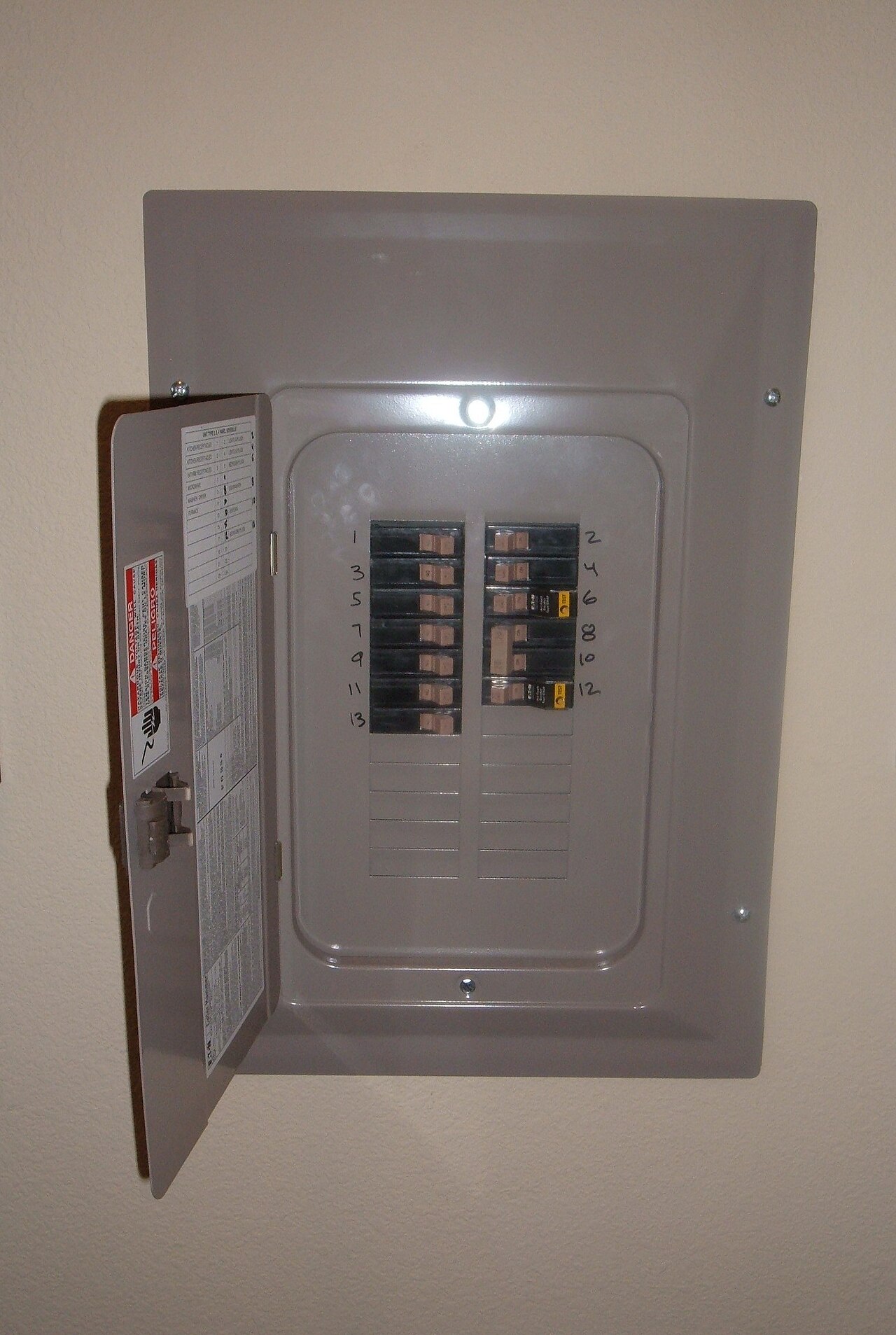 Quadro de disjuntores aberto mostrando os circuitos elétricos de uma residência
