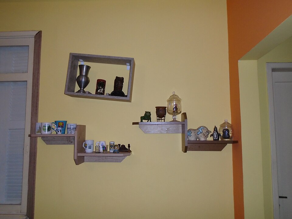 Prateleiras de madeira instaladas na parede com objetos decorativos