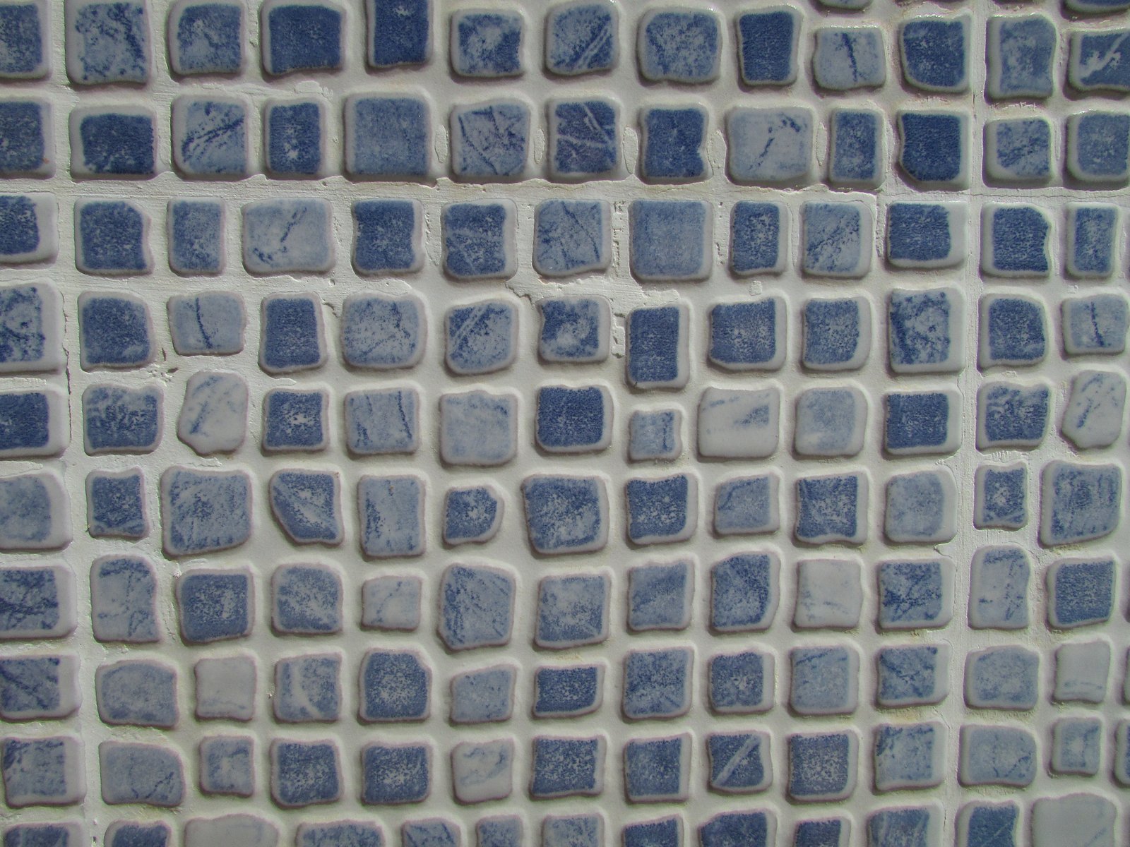 Piscina revestida com pastilhas de mosaico azuis, exemplo de aplicação que exige argamassa AC3