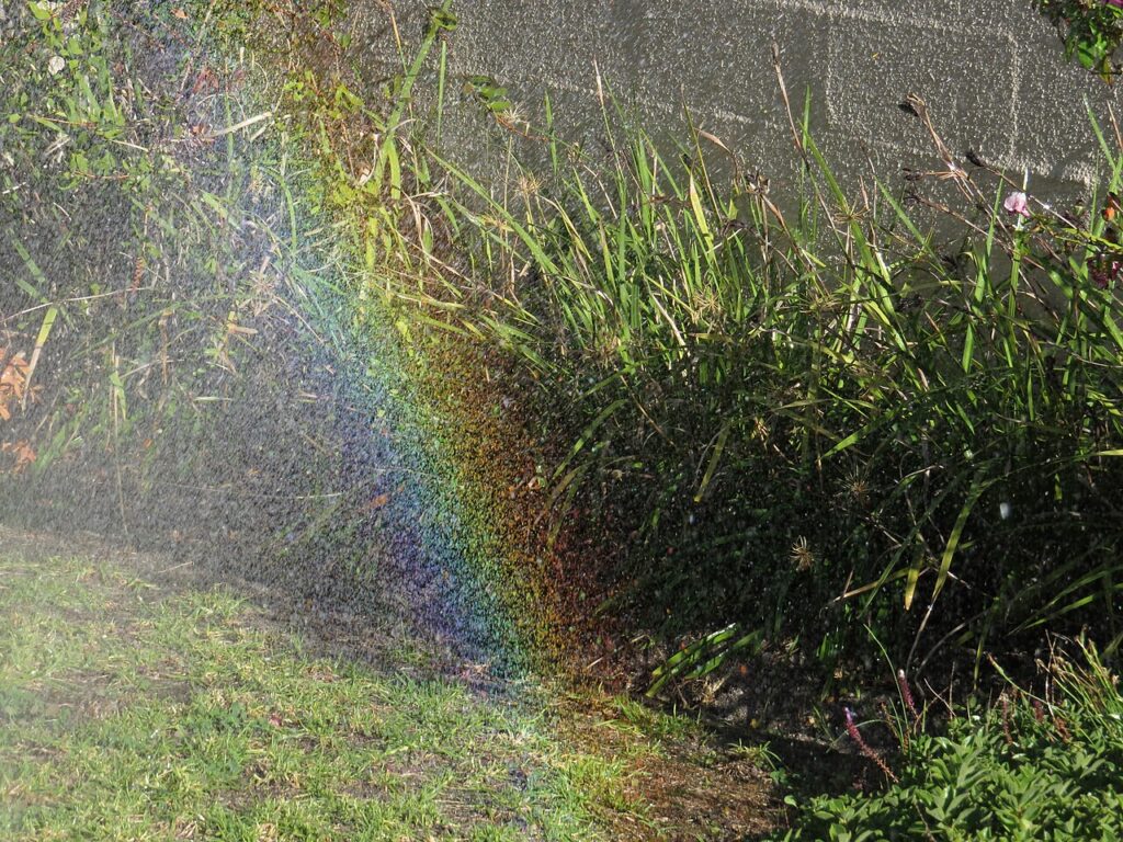 Aspersor de jardim giratório instalado no gramado, regando com jato em arco