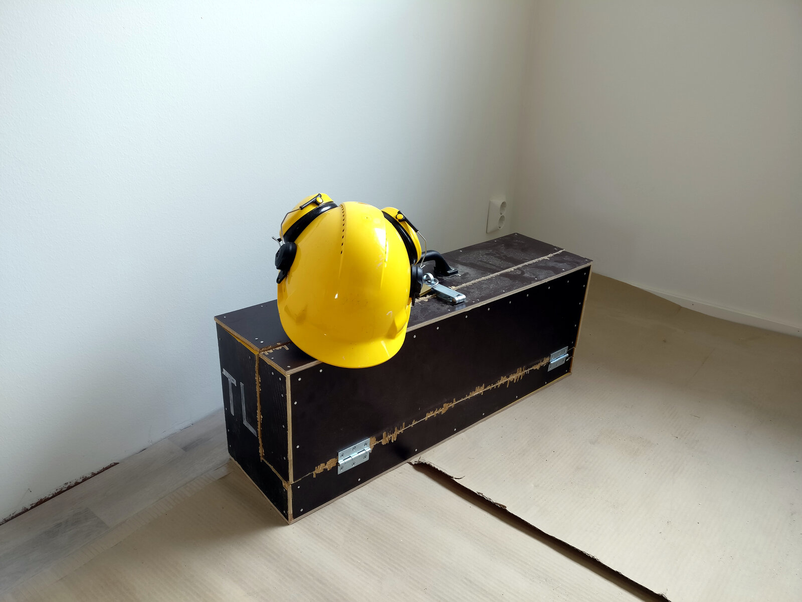 Maleta de ferramentas de obra ao lado de um capacete de segurança