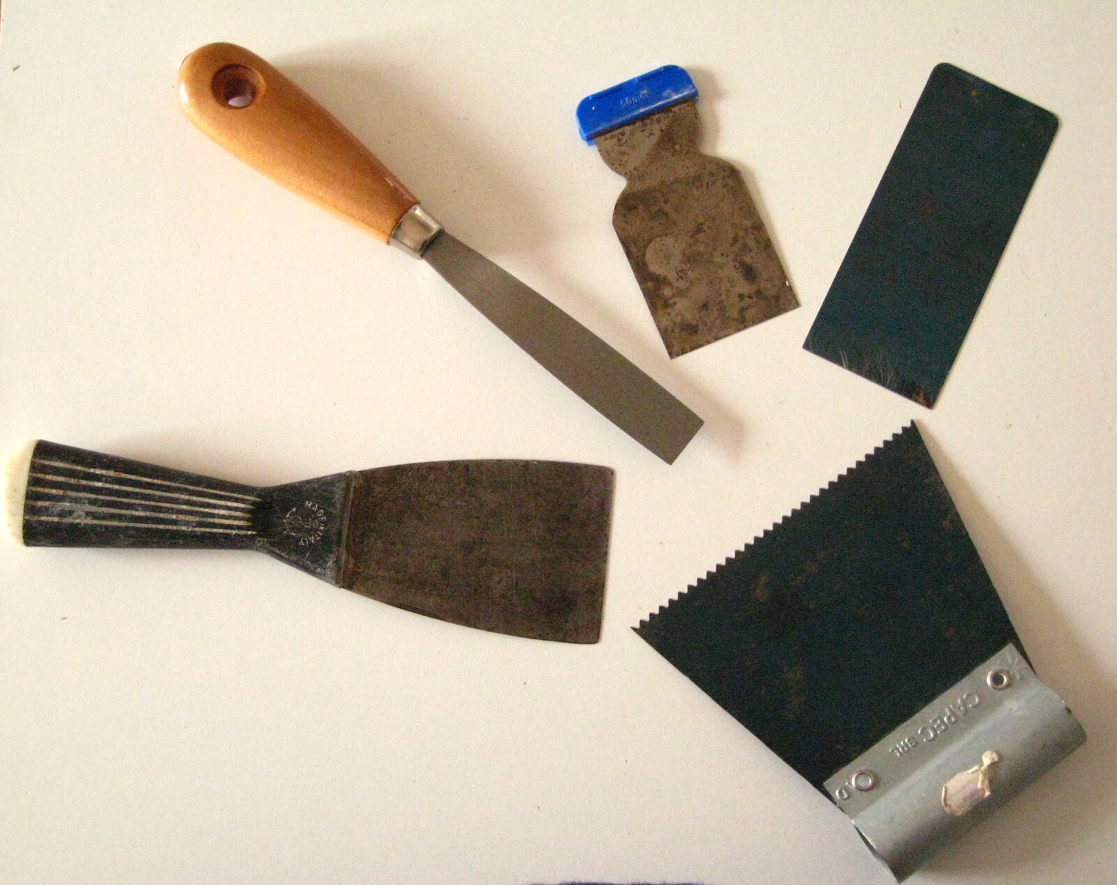 Diferentes tipos de espátula de pintor: cabo de madeira, cabo plástico, lâmina flexível e espátula dentada