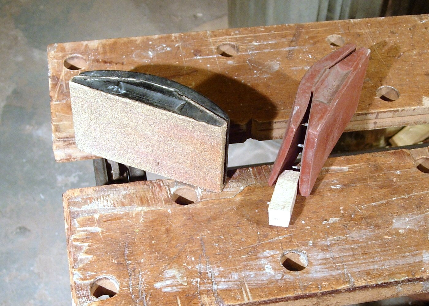 Blocos de lixar com lixa de papel presa, usados para preparar a superfície de madeira antes da pintura