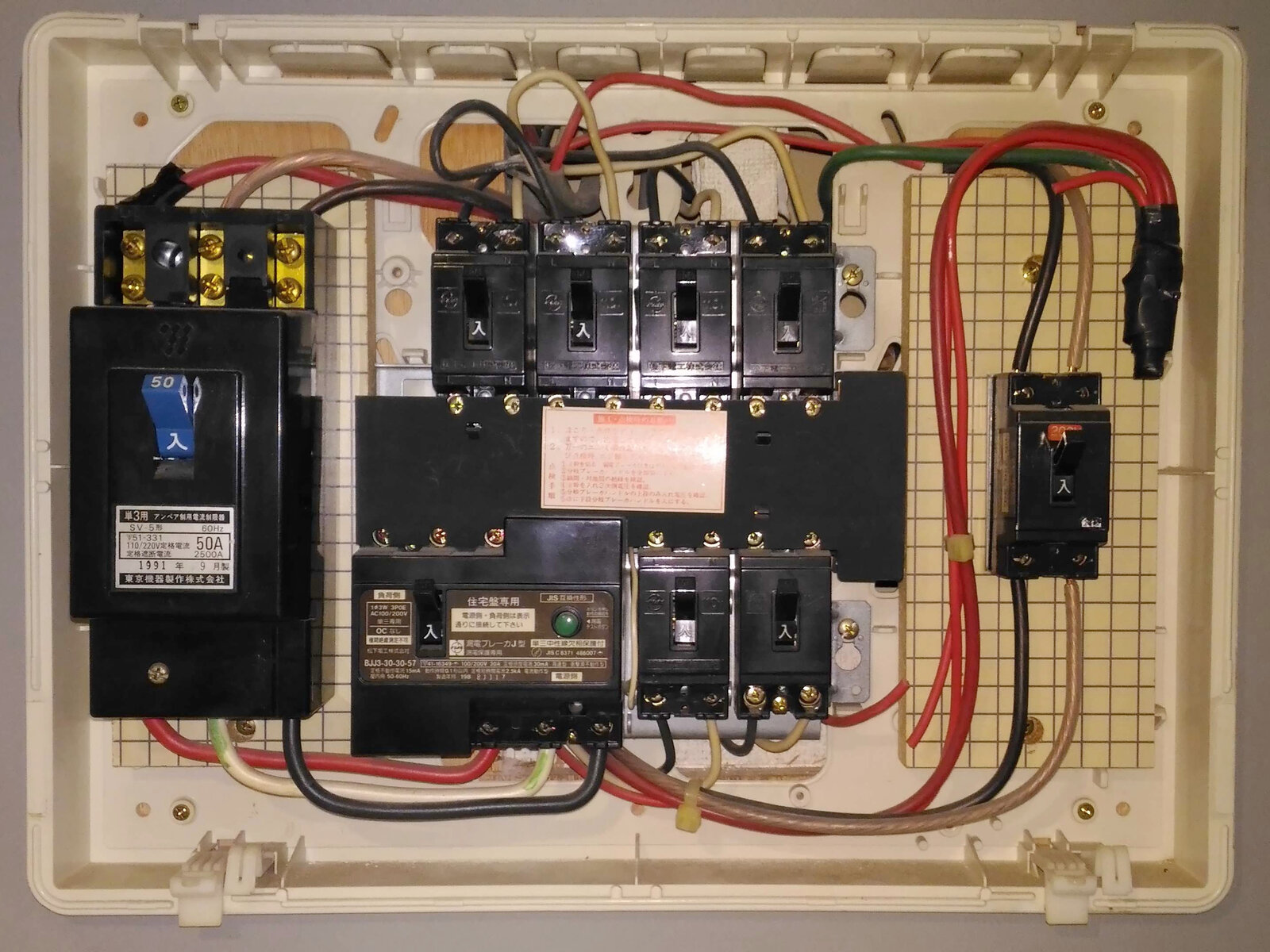 Quadro de distribuição elétrica residencial aberto, mostrando disjuntores organizados