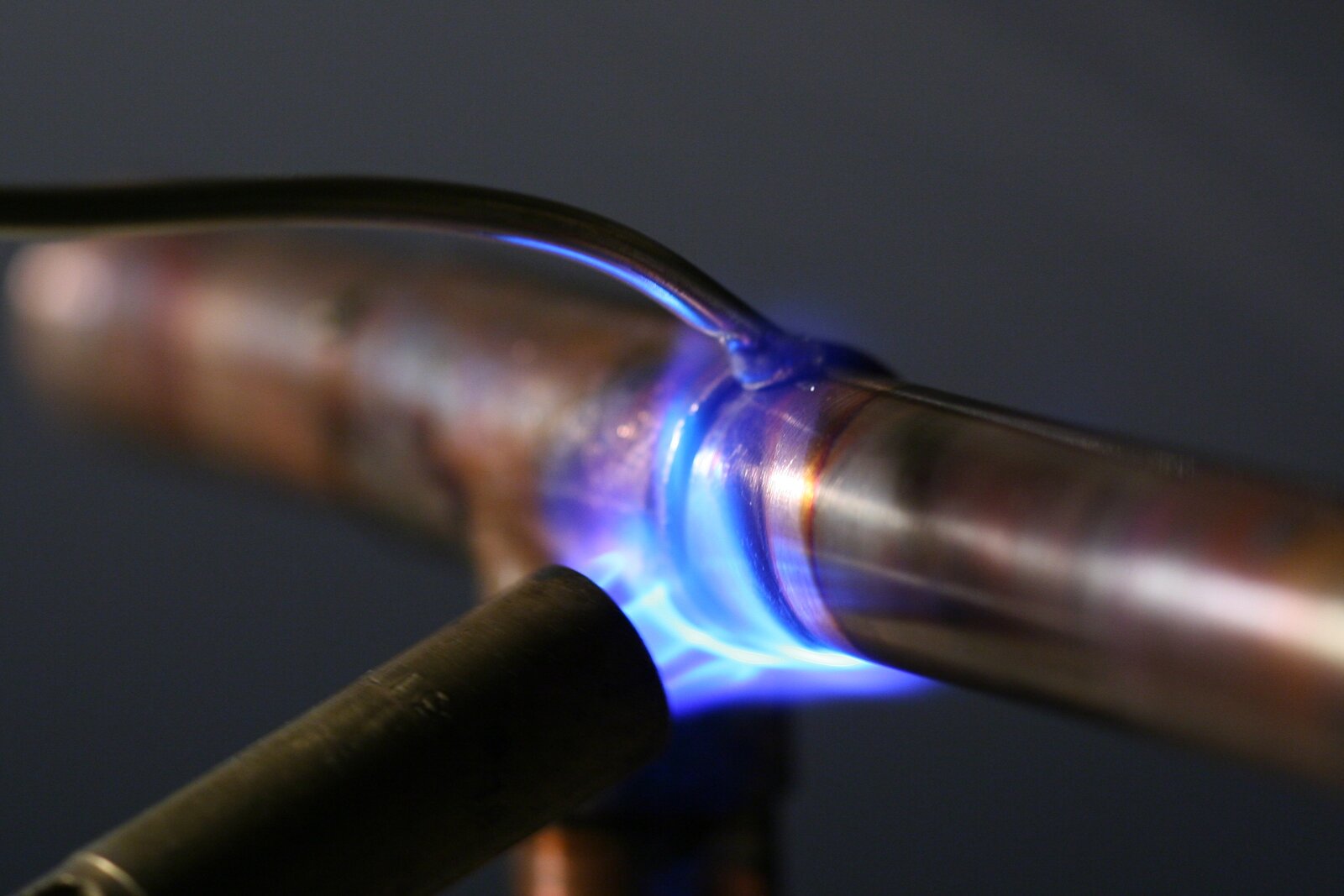 Chama azul de macarico a gas soldando junta de cano de cobre