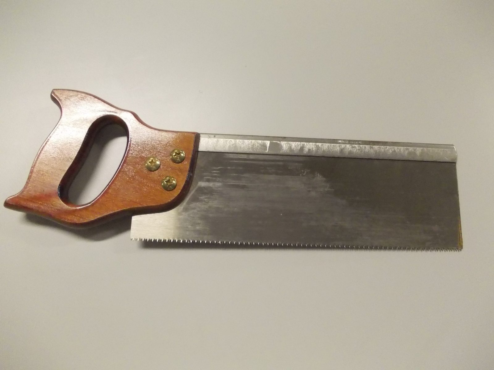 Serrote de costa (tenon saw) com reforço metálico no topo da lâmina, usado em marcenaria fina