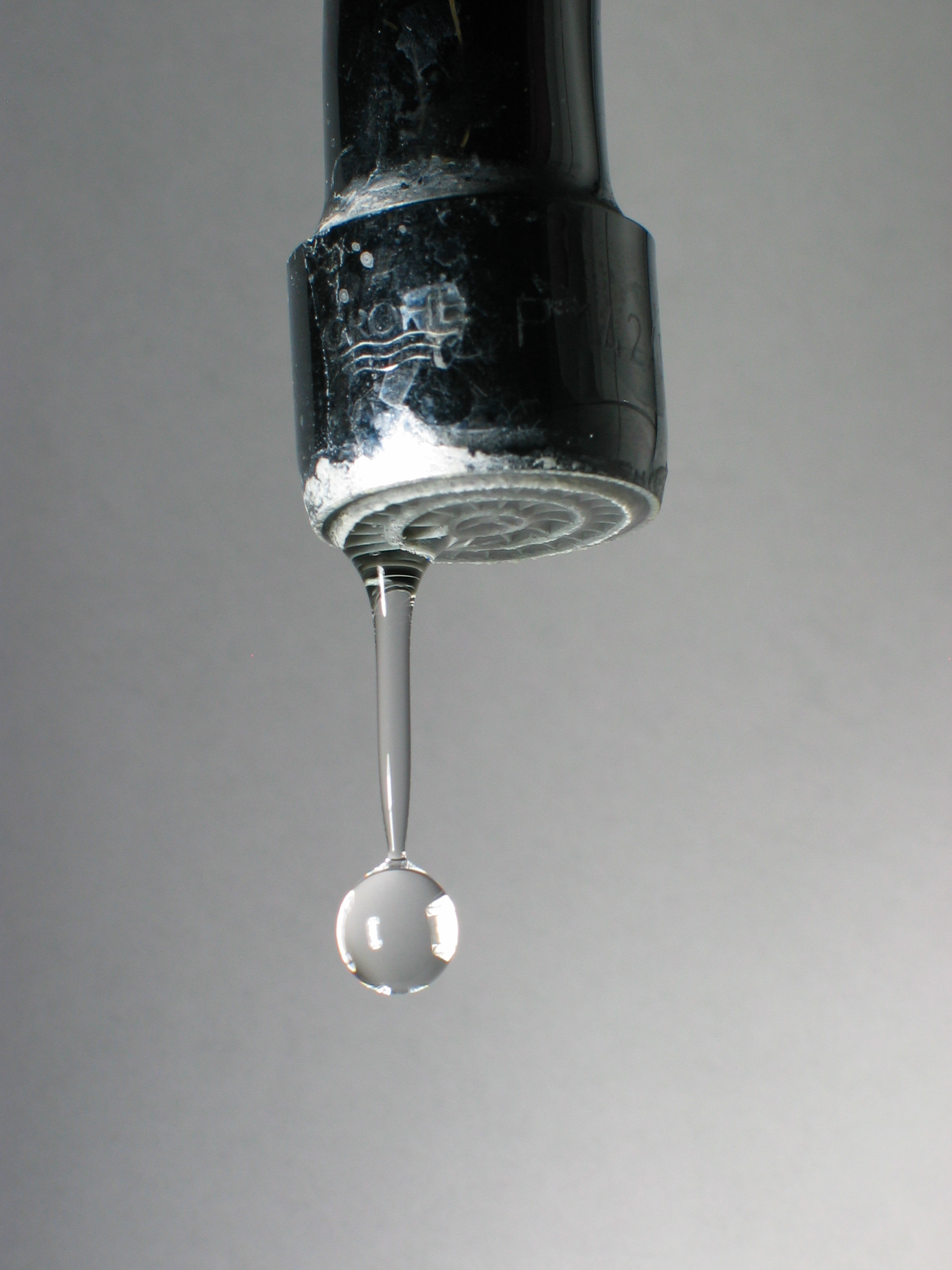 Gota de água se soltando de uma torneira pingando