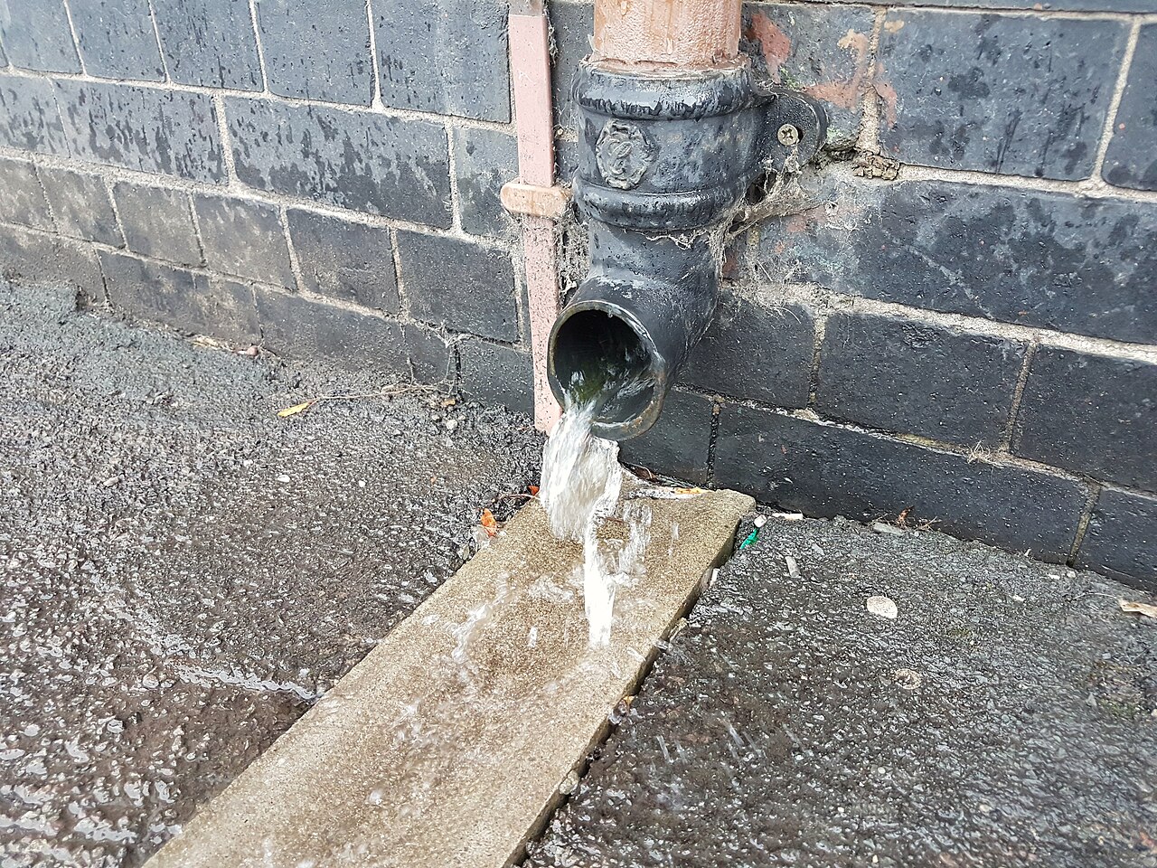 Tubo de descida (condutor vertical) conectado à calha, direcionando a água para longe da fundação